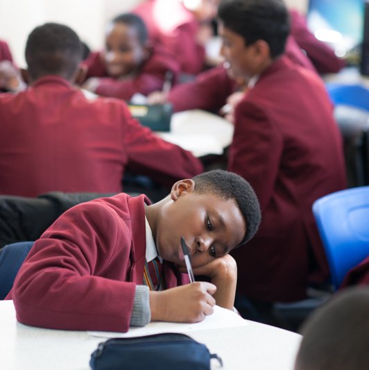 Boy writing in classroom