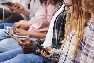 Teenagers looking at tablets and mobile phones