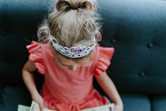 girl wearing crown reading a book.jpg